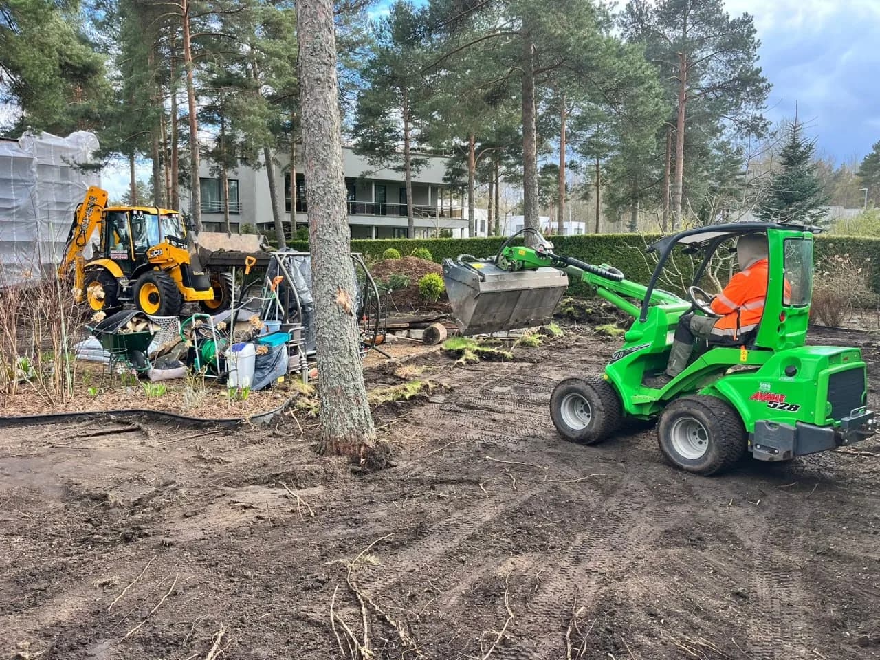 Loader and excavator clearing a garden plot